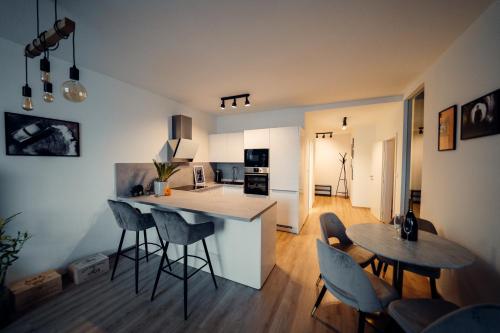 eine Küche und ein Wohnzimmer mit einem Tisch und Stühlen in der Unterkunft TIFFANY Apartment Hotel in Bratislava
