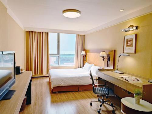um quarto de hotel com uma cama e uma secretária em Gueylin Hotel em Luzhu