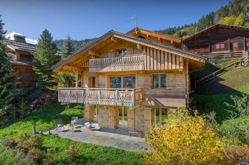 a log house with a balcony and a deck at Chalet Aravista - OVO Network in Le Grand-Bornand