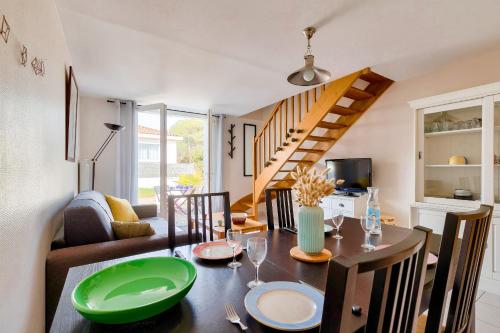 une salle à manger avec une table et une assiette verte dans l'établissement À deux pas de la plage, jolie maison pour 4, à Notre-Dame-de-Monts