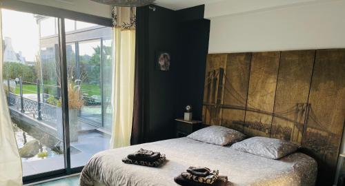 a bedroom with a bed and a large window at Villa du Sieck 5 étoiles in Santec