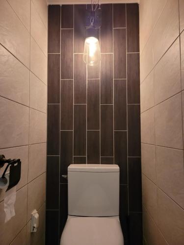 a bathroom with a toilet with a light above it at Sungsim Hanok Guesthouse in Jeonju