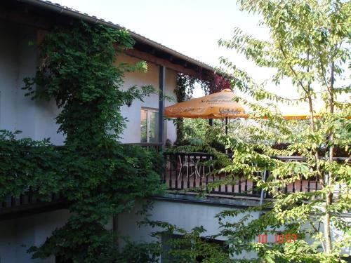 a balcony with an umbrella and tables and chairs at Stadthotel Brandenburger Hof in Neuruppin