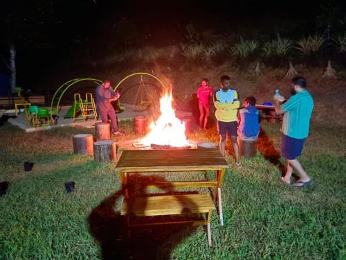 a group of people standing around a camp fire at Agronest Farm & Resort By Teal Luxury Stay in Wayanad
