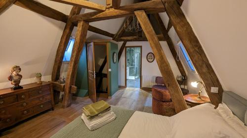 ein Schlafzimmer mit einem Bett und einer Kommode in einem Zimmer in der Unterkunft La Maison des Corporations in Noyers-sur-Serein