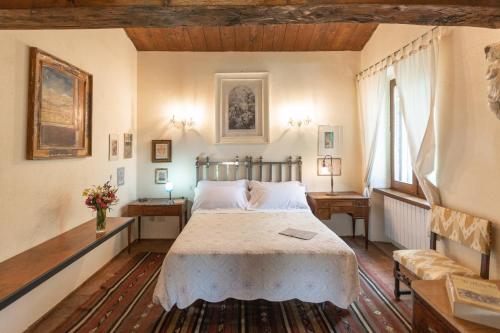 a bedroom with a bed and two tables and two windows at Agriturismo Fontenuova in Saturnia