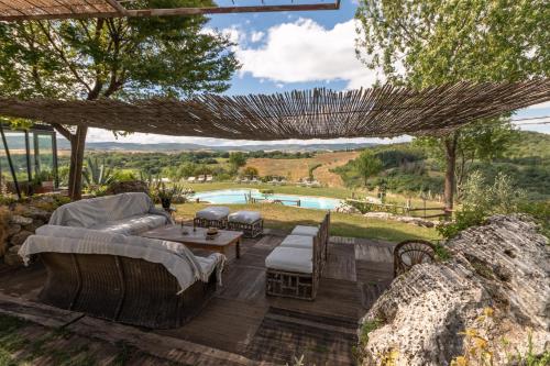 a patio with a couch and chairs and a table at Agriturismo Fontenuova in Saturnia