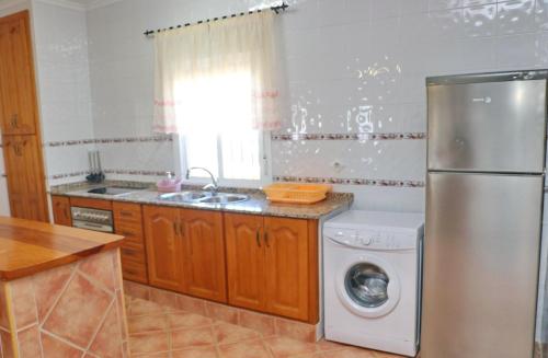 een keuken met een koelkast en een wasmachine bij Chalet Aroca in Conil de la Frontera
