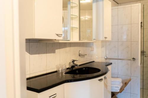 ein Bad mit einem Waschbecken und einem Spiegel in der Unterkunft Hotel Kijkduin in Domburg