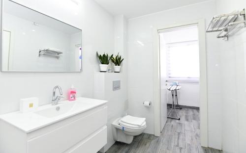 a white bathroom with a sink and a toilet at Kineret sheli- 4Bedrooms luxury apartment with stunning lake view in Tiberias