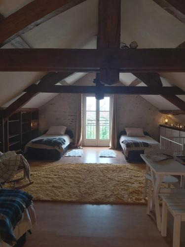 a attic room with two beds and a window at Chambre privée +thé et café 