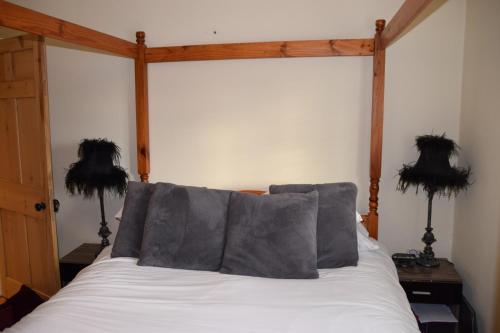 a bed with four pillows on it in a bedroom at Bluebell Cottage , 36 Main Street in Alveston