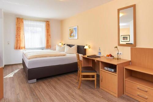 a hotel room with a bed and a desk with a computer at Gasthof Gigl in Neustadt an der Donau