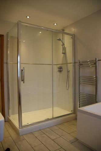 a bathroom with a shower with a glass door at Bluebell Cottage , 36 Main Street in Alveston