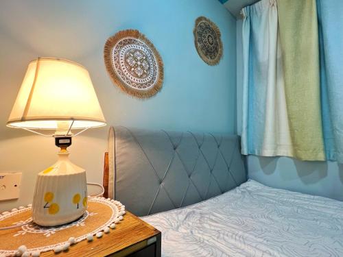 - une chambre avec un lit et une lampe sur une table dans l'établissement AMU Dreamhouse 阿木旅舍, à Hong Kong