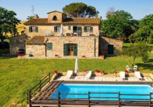 a house with a swimming pool in front of a house at Podere I Sorbi, Spacious Tuscan Villa, Lajatico, Nr Pisa in Molino Mazzetti