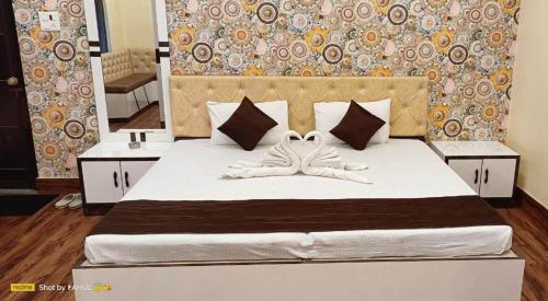 - une chambre avec un grand lit blanc et un grand miroir dans l'établissement Hotel WB40, à Durgapur
