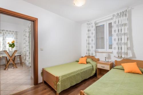 a bedroom with two beds and a table with a dining room at Two-bedroom apartment NIKI near Rovinj in Rovinj