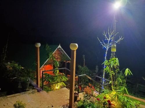 a night view of a house with a light on it at Agronest Farm & Resort By Teal Luxury Stay in Wayanad