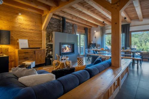 ein großes Wohnzimmer mit einer langen blauen Couch in der Unterkunft Chalet Les Vosnes - OVO Network in Domancy