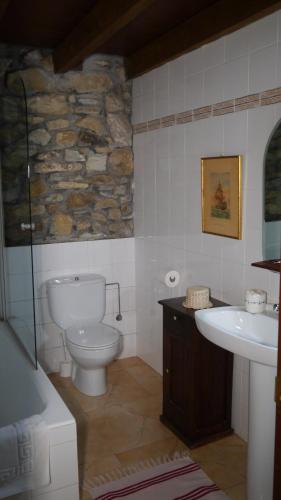 a bathroom with a white toilet and a sink at Casa Rural Garro in Guerricaiz
