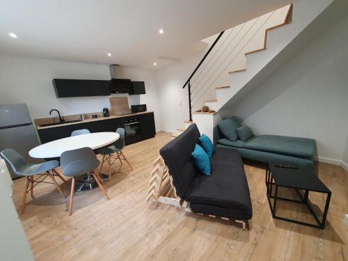 a living room with a couch and a table at Appartement chic et cosy in Authézat