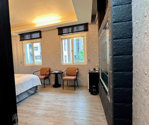 a room with a bed and a table and chairs at 沐-湯宿溫泉行旅 in Jiaoxi