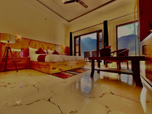 a bedroom with a bed and a desk and windows at The Kempty Fall Resort, Mussoorie in Mussoorie