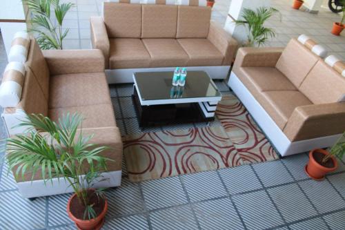 a living room with two couches and a coffee table at Hotel Prime Classic in Shamshabad