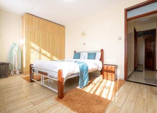 a bedroom with a large bed and a dresser at Art-inspired 3BR Apartment in Nairobi