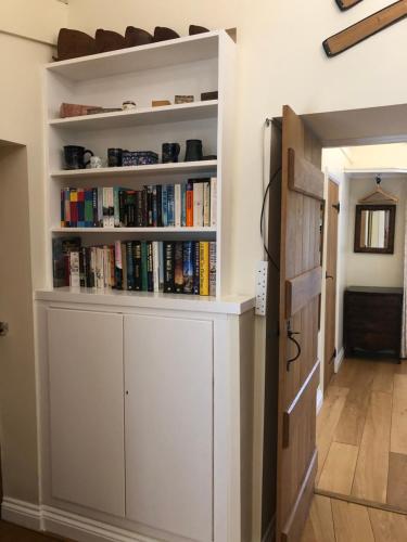 a book shelf with books on it next to a door at Church Hill Farm in Lighthorne
