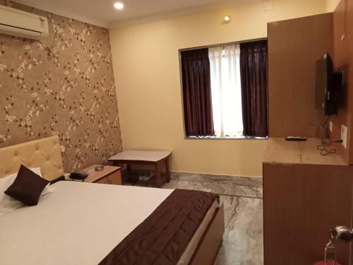 a hotel room with a bed and a window at Hotel WB40 in Durgāpur