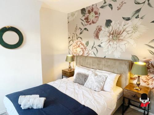 ein Schlafzimmer mit einem Bett und Blumen an der Wand in der Unterkunft KozyGuru / 2 BR 4Bed / Blossom Garden / Next to Big Retail Park and Train station / Worsley Manchester / 16 mins to City Centre / UMWO187 in Worsley