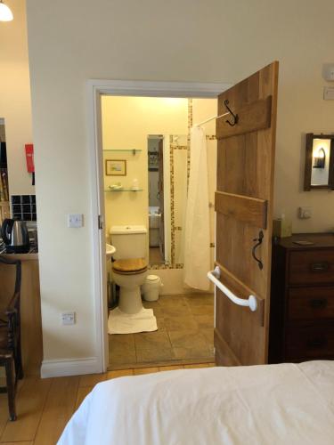 a bedroom with a bathroom with a toilet and a shower at Church Hill Farm in Lighthorne