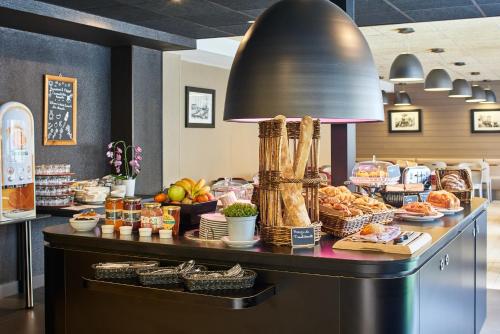 ein Buffet mit Speisen auf einer Theke in einem Restaurant in der Unterkunft Campanile Hotel Nice Centre Acropolis in Nizza