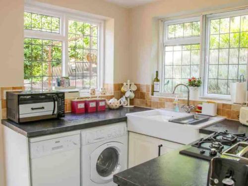 uma cozinha com uma máquina de lavar roupa e um lavatório em Charming 1-Bed Cottage located in Ironbridge em Ironbridge