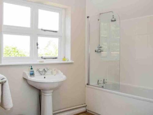 a white bathroom with a sink and a shower at Charming 1-Bed Cottage located in Ironbridge in Ironbridge