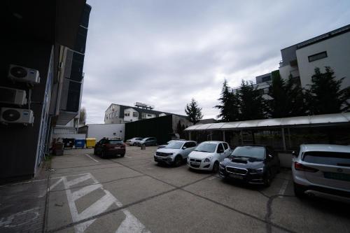 a group of cars parked in a parking lot next to a bus at TIFFANY Apartment Hotel in Bratislava