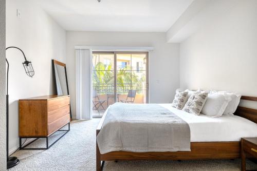 a white bedroom with a bed and a balcony at Playa del Rey 1BR w WD Gym Pool nr beach LAX-412 in Los Angeles