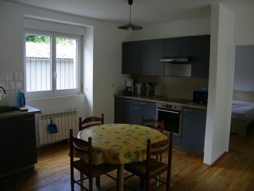 eine Küche mit einem Tisch und Stühlen sowie eine Küche mit einem Bett in der Unterkunft Appartement Cransac 2 in Cransac