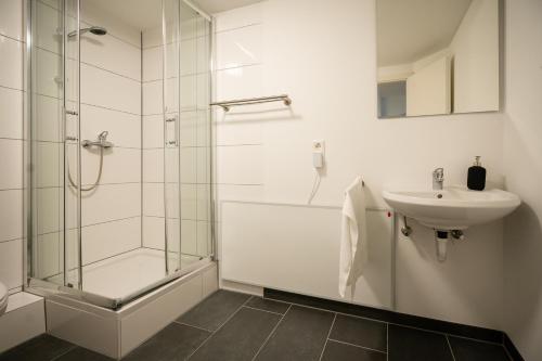 a bathroom with a glass shower and a sink at Oldtown Studio Apartment with 2 Bathrooms in Düsseldorf