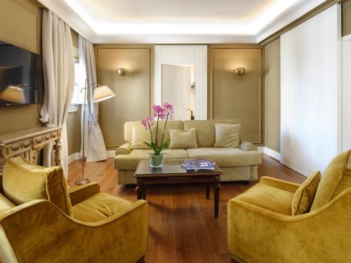 a living room with a couch and two chairs and a table at Hotel Regency - Small Luxury Hotels of the World in Florence