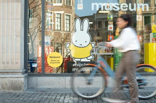 a person riding a bike in front of a store at Stayokay Hostel Utrecht Centrum in Utrecht