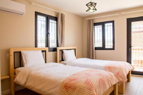two beds in a room with windows at Fully Furnished and Stylish Villa in Izmir in Izmir