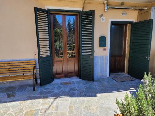 a wooden door and a bench in front of a building at Il Pozzo in Tremezzo