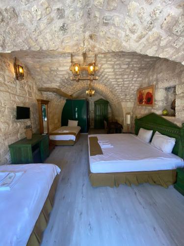 a bedroom with two beds in a stone room at HANEHAN in Urfa