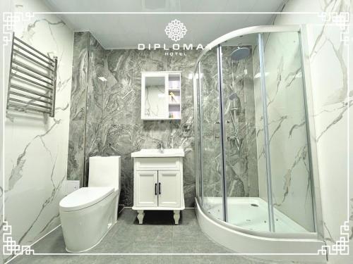 uma casa de banho com um chuveiro, um WC e um lavatório. em Diplomat Hotel em Ulan Bator