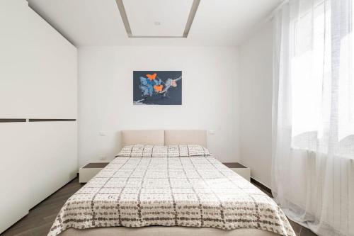 ein Schlafzimmer mit einem Bett in einem weißen Zimmer in der Unterkunft Villa Vanessa Milazzo, Sicily - EV Charge Station in Milazzo
