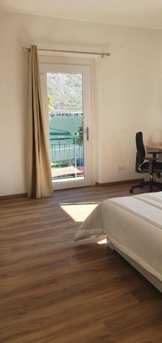 a bedroom with a bed and a desk and a window at L For Lake in Mandello del Lario