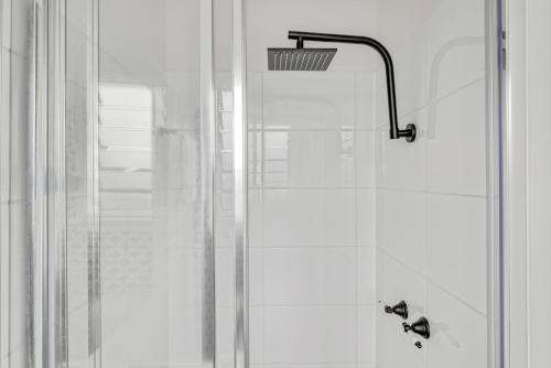 ducha con puerta de cristal y cabezal de ducha en Alps Lakeview Lodge en Jindabyne